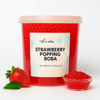 Red container of strawberry popping boba with a strawberry and bowl of boba on a white background